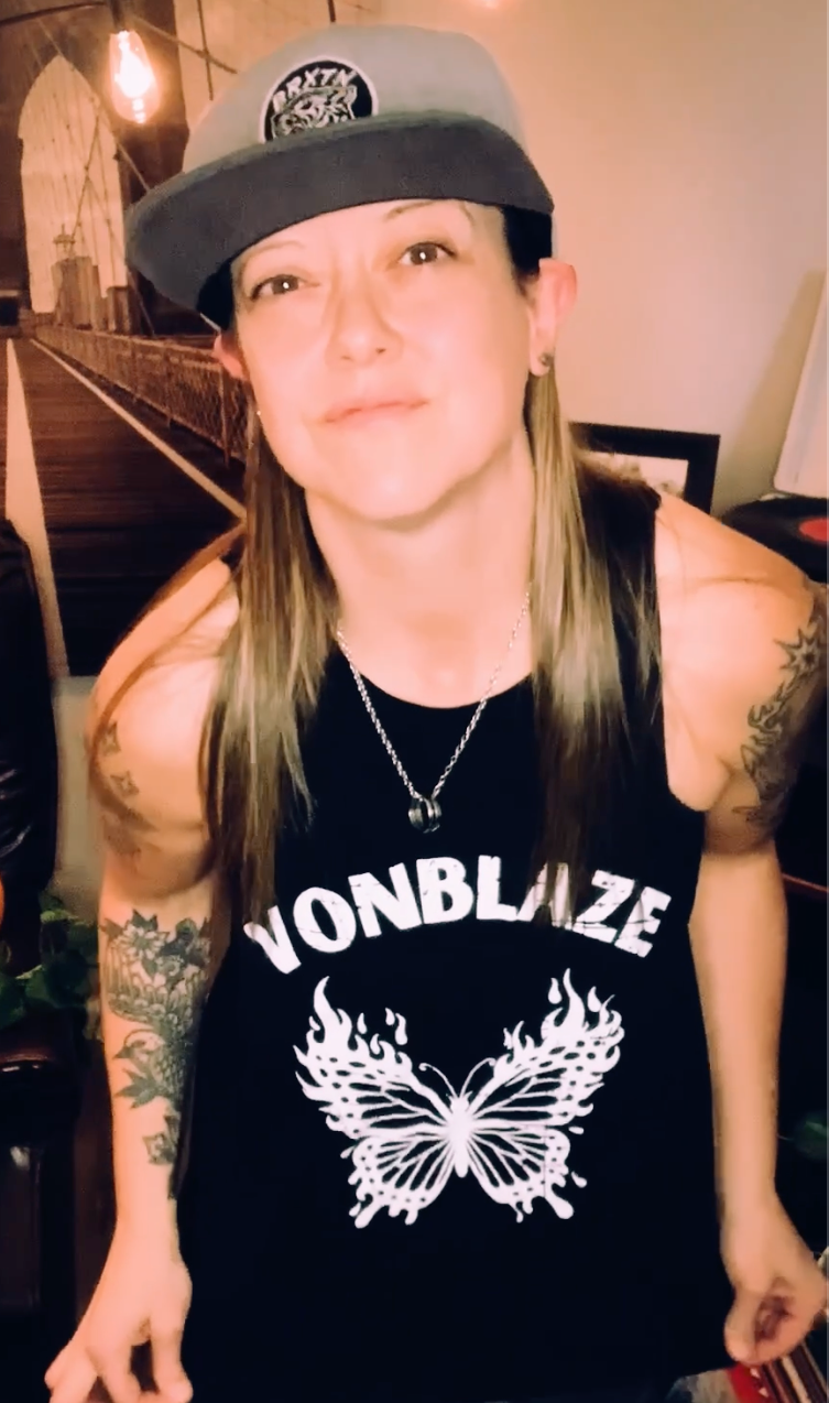 muscular guy sitting in the back of a car wearing vonblaze tshirt and aviators